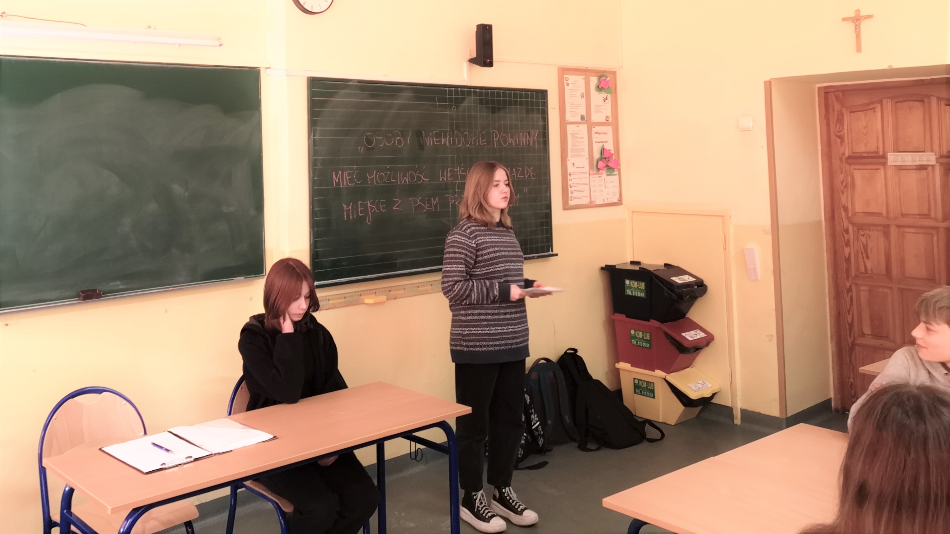 Zdjęcie przedstawiające młodzież prowadzącą debatę oksfordzką w jednej z sal w szkole.